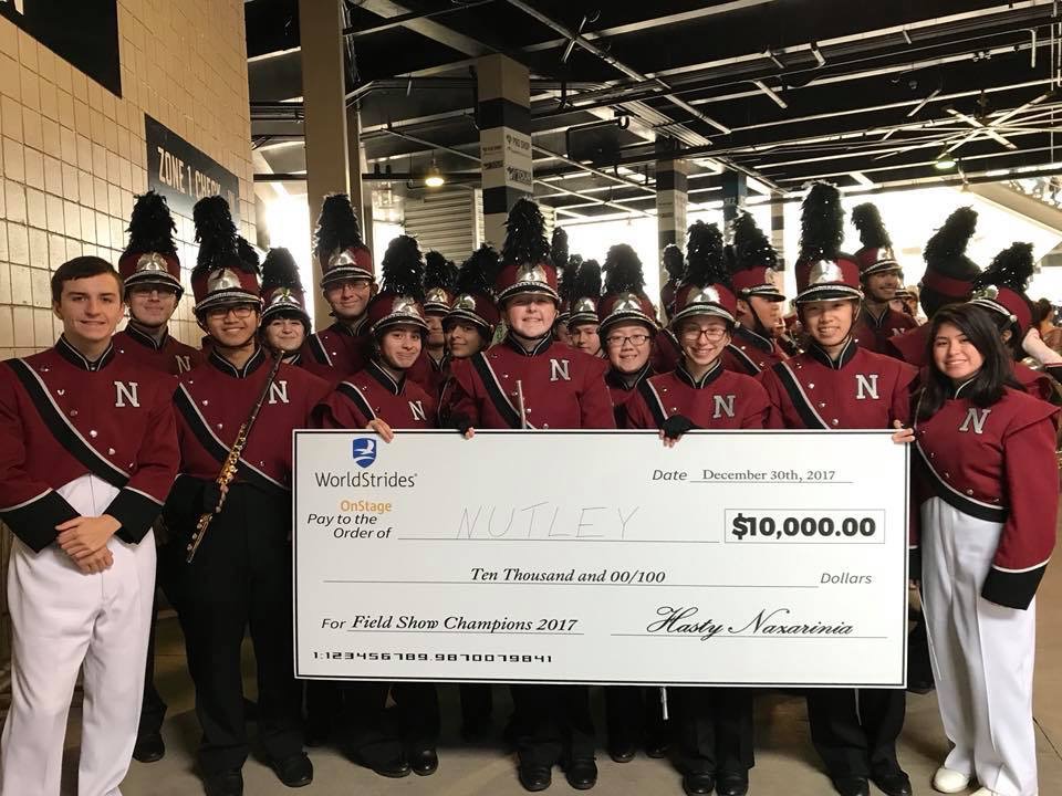 The band poses with the check before performing pregame, photo: Nutley Music Boosters Association