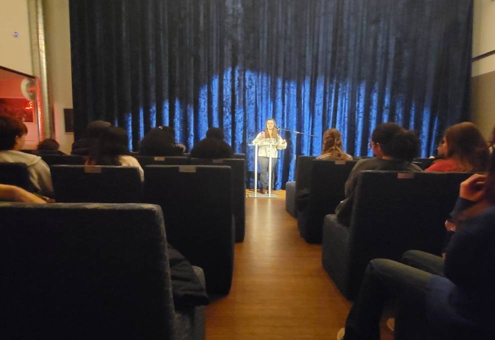 Senior Haley Papeo performing poetry in front of an audience.