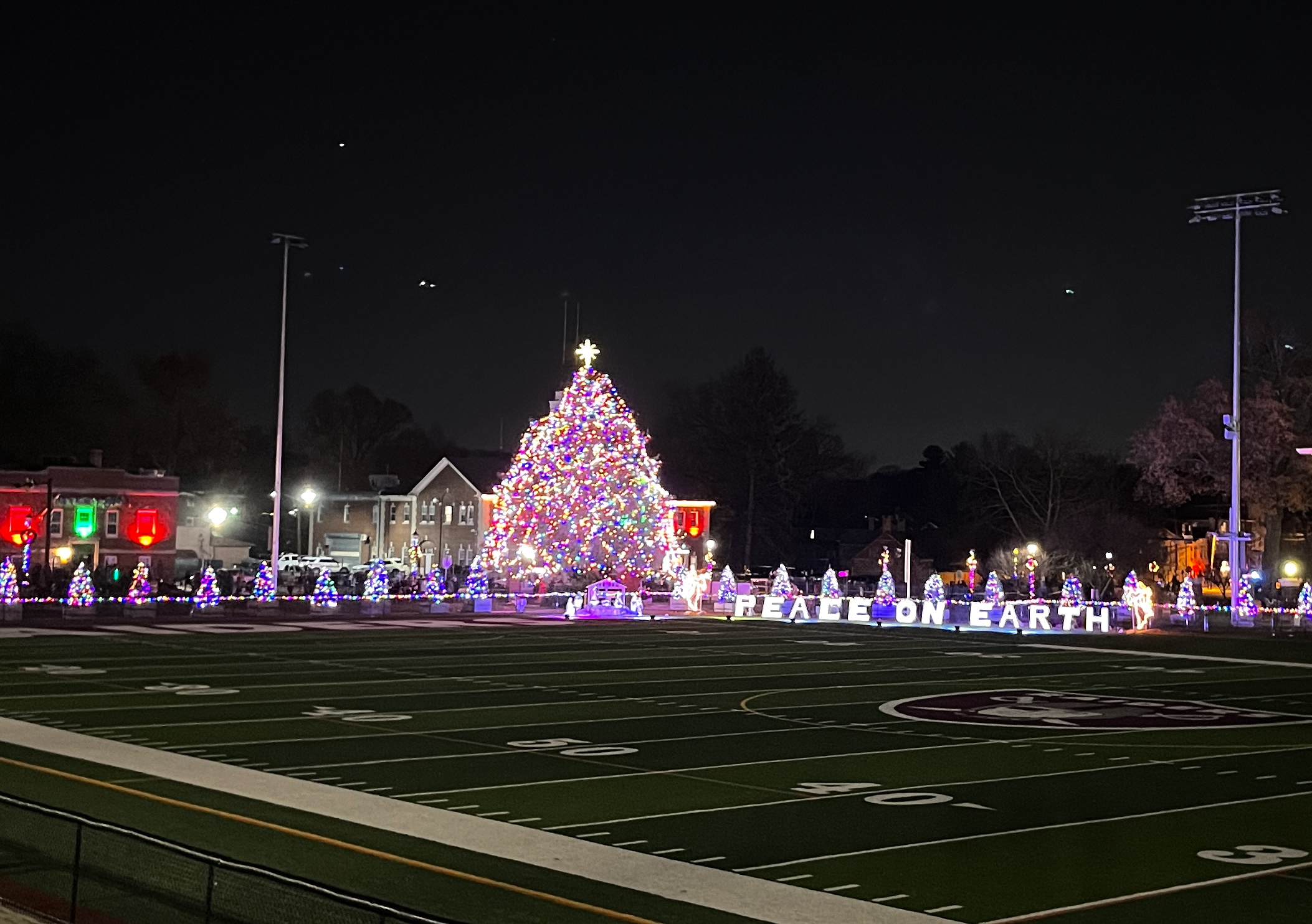 Nutley's 60 foot christmas tree filled up with light, "Peace on Earth" sign lit beside it