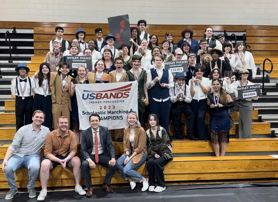 The Indoor Percussion Ensemble smiling and holding a banner declaring them USBands Scholastic A Champions