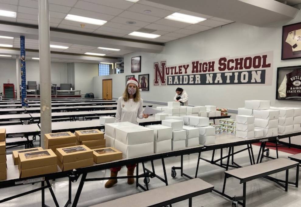 Mrs. D'Urso in the cafeteria with many boxed desserts for Key Club.