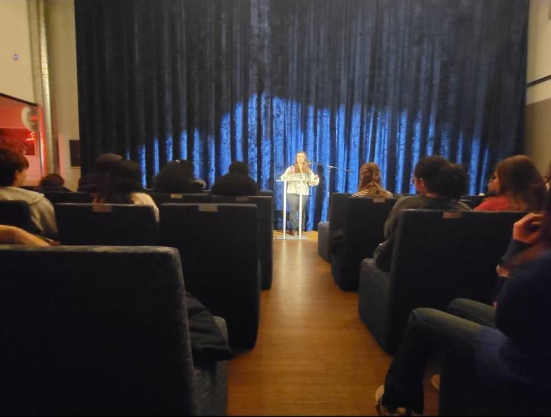 Senior Haley Papeo performing poetry in front of an audience.