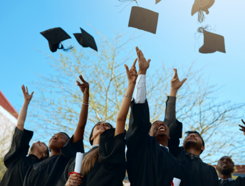 A graduating class throwing their caps in the air.